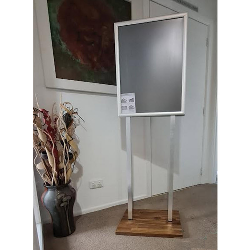 Double Sided Snap Frame Display Anodized Silver A2 Poster Stand on Hardwood Base. 2 x 25mm Profile Snap Frames Anodized Silver Takes Poster Size A2 Portrait format 420mm wide x 594mm high with visible area 411mm w x 585mm h Assembled height 1520mm to top of frame Snap Frames Supplied with Clear PVC Poster Cover Sheets Square 30mm Metal, uprights Natural Anodized Silver Hardwood Base 460mm w x 350mm d with 4 non slip rubber pad feet